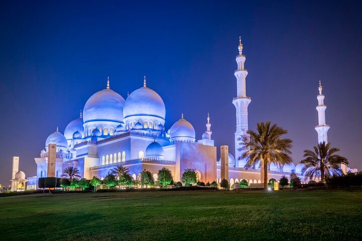 Experience the stunning nighttime illumination of the Sheikh Zayed Mosque a masterpiece of modern architecture surrounded by lush gardens and reflecting pools that embody the essence of Abu Dhabi.